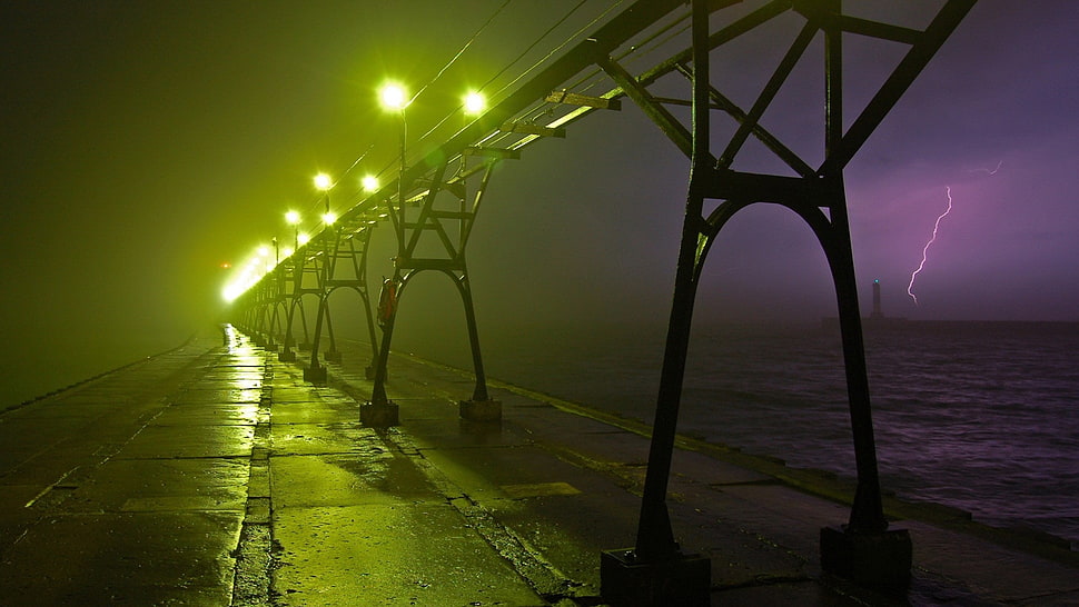 grey concrete bridge near body of water during nighttime HD wallpaper