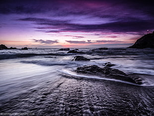 photo of black rock formation in sea during night time, devon HD wallpaper