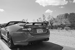 black Toyota Corolla E100 sedan, Jaguar (car), sports car, desert, monochrome