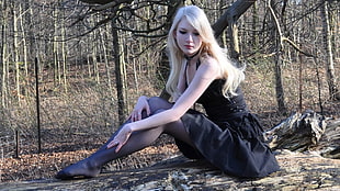 woman wearing black sleeveless dress sitting on ground near trees HD wallpaper