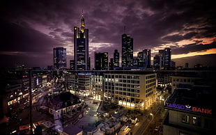 lightened buildings under gray cloudy sky during sunset