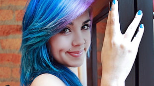 blue haired woman standing near on black wooden base glass panel window