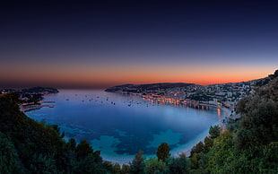 aerial photography of body of water between mountains under golden hour