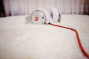 white Beats headphones on white textile HD wallpaper