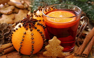 ripe orange fruit near clear glass mug