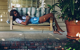 woman laying on bench swing near plant HD wallpaper
