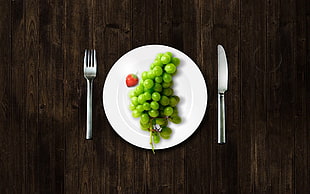 green grapes on white ceramic plate with spoon and fork beside on brown wooden table HD wallpaper