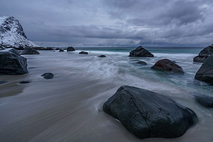 black sea rock,with body of water,and blue skies photography during daytime