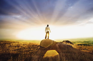 man in white shirt standing in rock with reflection on sun during daytime HD wallpaper
