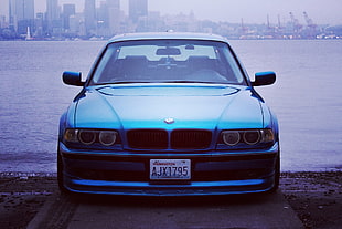 blue BMW sedan in seashore HD wallpaper