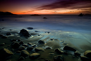 rocks on seashore during sunset HD wallpaper