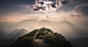 mountain under clouds with sun rays landmark