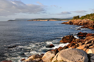 body of water near brown stone