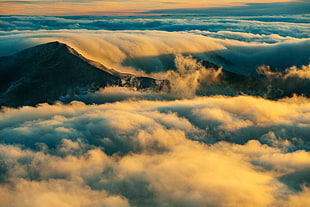 high-rise photography of thick clouds and mountain during golden hour HD wallpaper