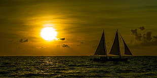 silhouette photo of a two sailboats in bodies of water with sun background HD wallpaper