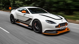 timelapse photography of white and orange Aston Martin coupe