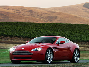 red Aston Martin Vanquish on asphalt road