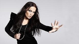 woman in black long-sleeved dress standing with white background