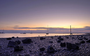 landscape photo of rock formations on seashore during sunset