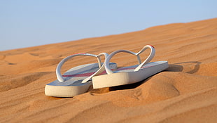 two white flip-flops on desert during daytime HD wallpaper