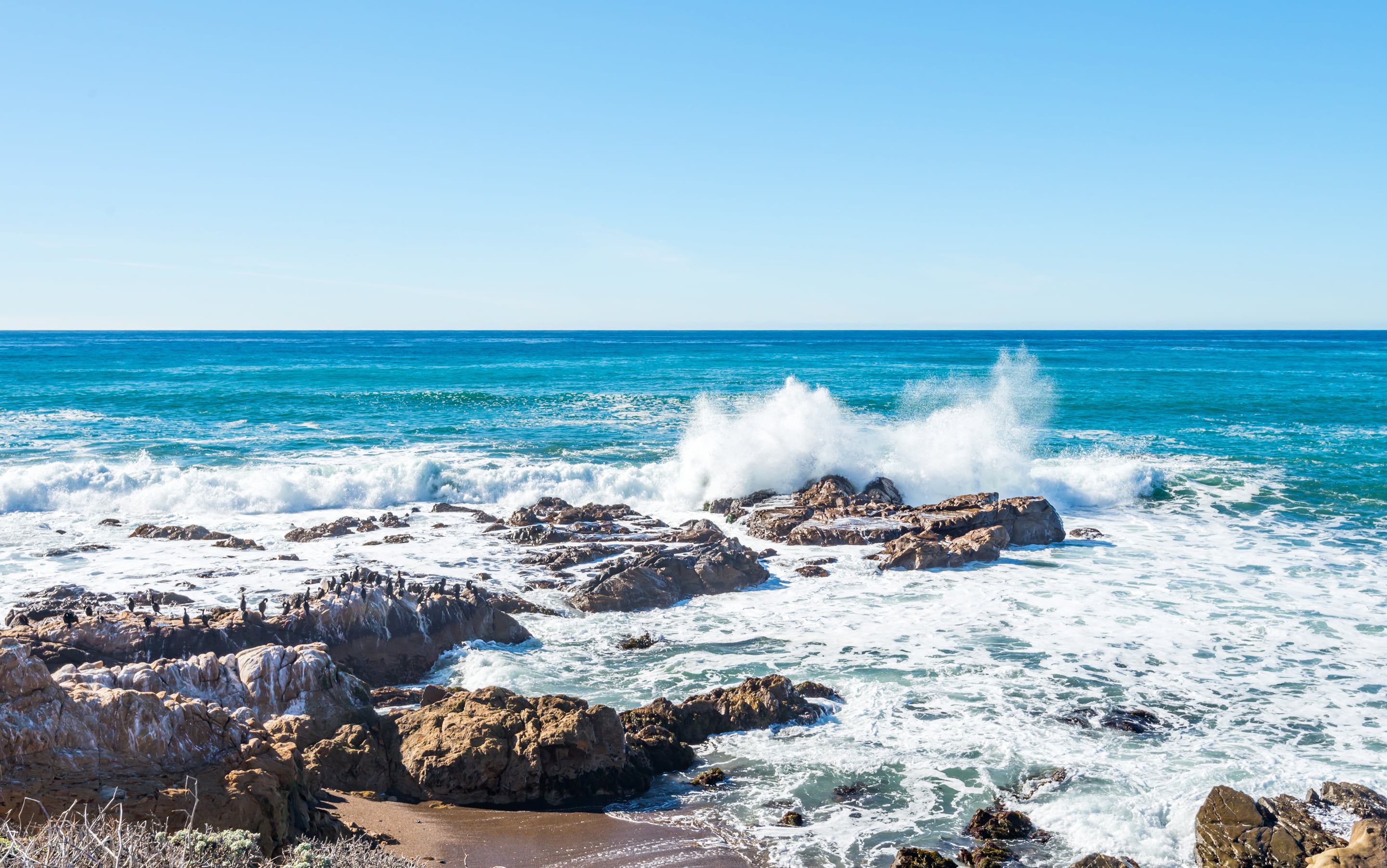 beach waves hit on stone at daytime