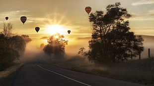 silhouette photo of hot air balloons with fog during golden hour HD wallpaper