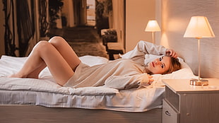 woman wearing long-sleeved dress lying on white bed comforter set HD wallpaper