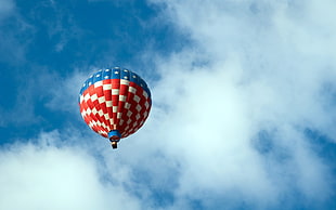 low-angle photography of hovering white and red hot air balloon