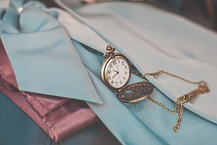 round gold-colored pocket watch