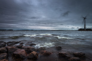 Windmill on island under gray sky