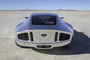 silver Ford super car on desert under clear sky HD wallpaper