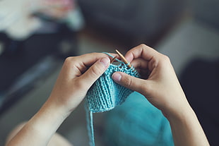 person holding blue knit cap