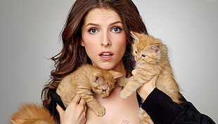 Hollywood actress holding two orange tabby kittens