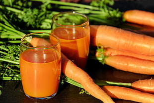 closeup photography of pile of carrots and two carrot juices HD wallpaper