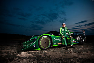 man wearing green racing suit sitting on green sports car digital wallpaper