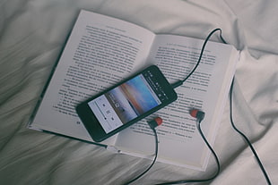 black smartphone with red-and-black earphones