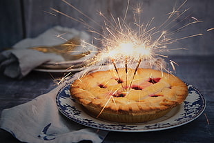 time lapse photography of lighted sparkler candles on top of baked pie HD wallpaper