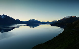 lake surrounded by mountains during sunrise