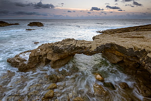 timelapse photography of rock formation under nimbus clouds