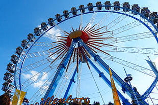photo of blue and red Ferris wheel during day time