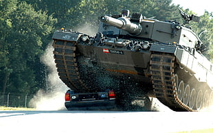 gray military tank wrecking the black car HD wallpaper