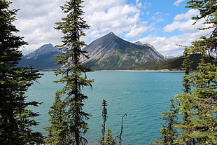 mountains near on body of water under blue cloudy sky, upper kananaskis lake