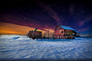 brown wooden house with fence and shed on white ground during starry night HD wallpaper