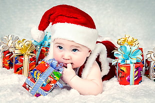 baby in santa hat surrounded by gift boxes HD wallpaper