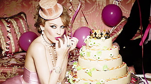 woman in pink sleeveless dress eating cake