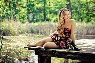 woman in black and red floral strapless dress on boardwalk