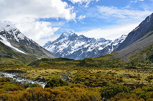 mountain covered white snow under white clouds