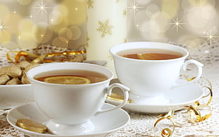 two ceramic teacups with saucers filled with tea