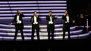 four men wearing black-and-white suits standing on stage HD wallpaper