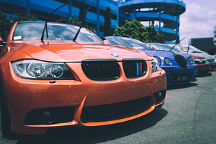 close up photo of orange BMW car at daytime HD wallpaper